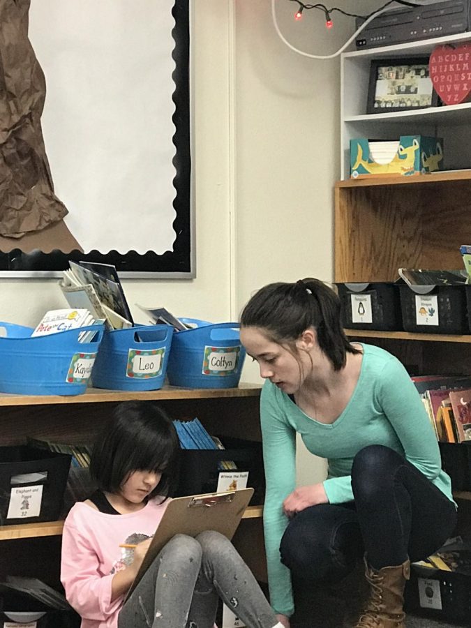 Brianna Pittman helps a first grader in Taylor Neibauer’s class during her career internship seventh period. 
