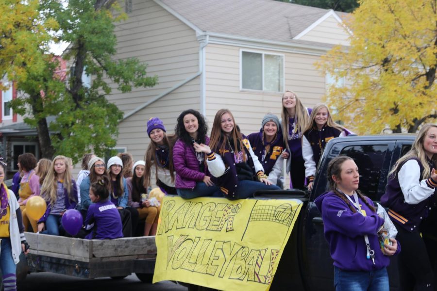Volleyball+players+show+off+their+purple+and+gold+spirit+in+the+homecoming+parade+