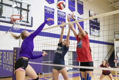 Emma Warhank and Hailey Strupp attempt to block a spike by Taylor Young during practice last week.