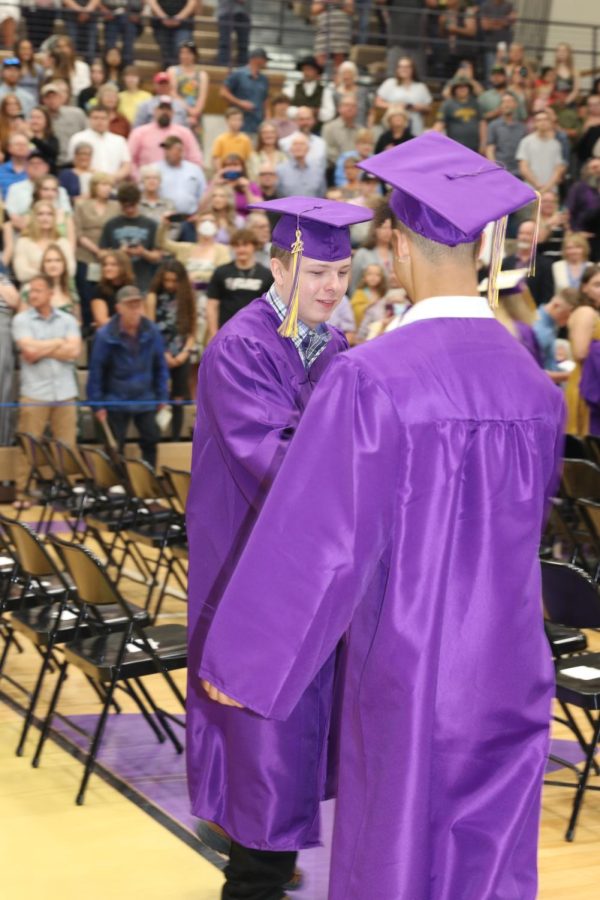 Zach Beal shakes the hand of his graduation walking partner, Giovanni Page, as they head up the aisle to be seated for the ceremony.