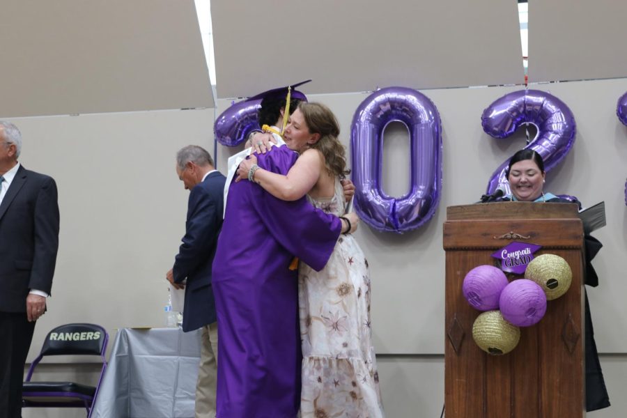 Fifth grade teacher Megan Brenna hugs her son, Gabe Holmes, after awarding him his diploma.