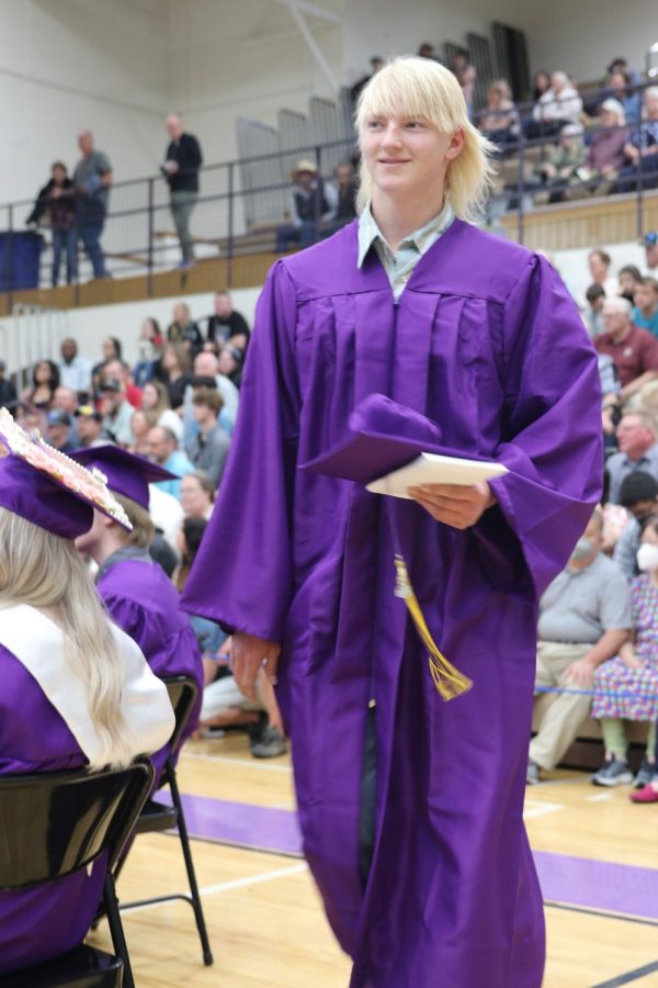 Colter Edwards heads back to his seat, cap and diploma in hand.