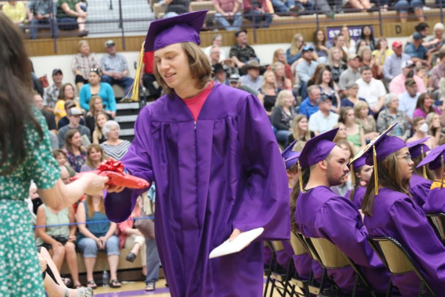 Max Stern receives a gift from English teacher Carol Powalisz as he returns to his seat after graduating.