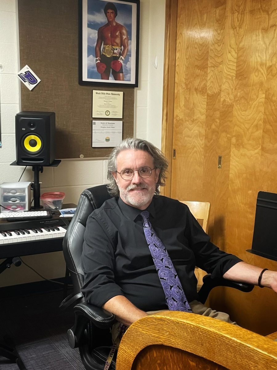 New choir teacher, Douglas Olson sits in his office last week. 