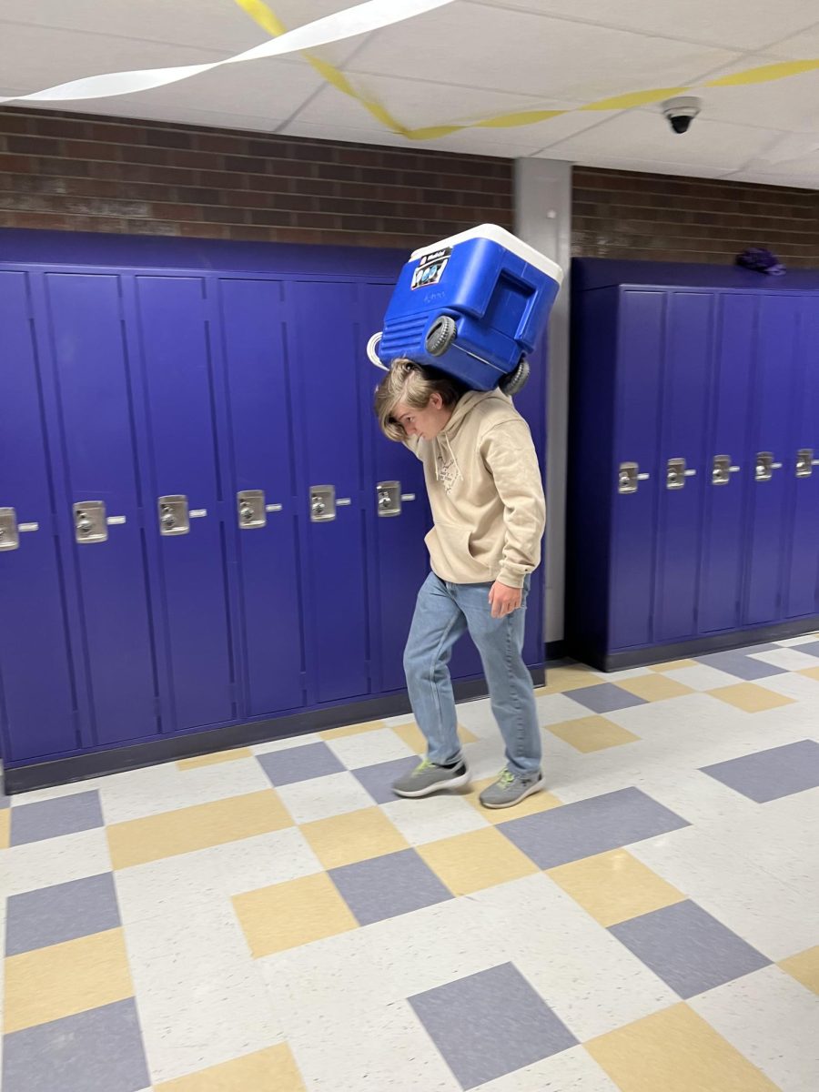 Beau Blakeley lugs his cooler on wheels through the halls before school Tuesday.
