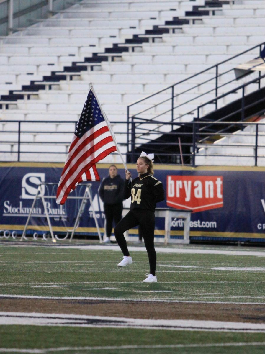 Senior Meryl Sexton carries out the American Flag for the National Anthem at MSU Stadium.