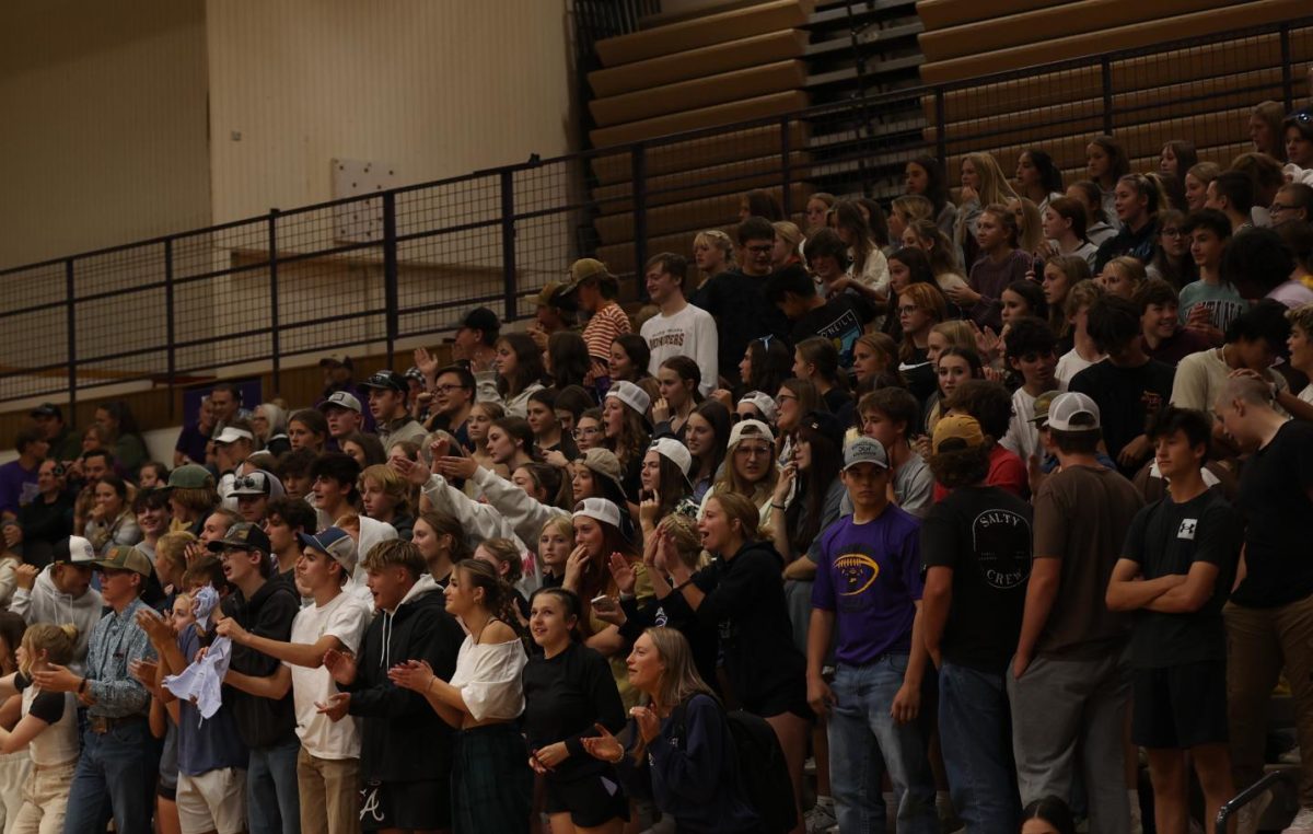 The packed student section cheers loudly for the Iron Man volleyball game.