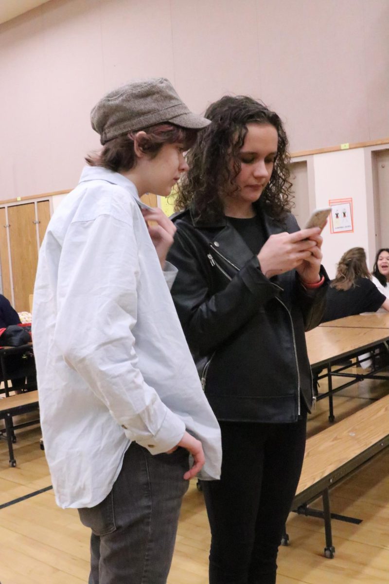 Sophomores Ismay Johnstone and Esme Grady wait together for postings at the Speech and Debate meet on December 16.