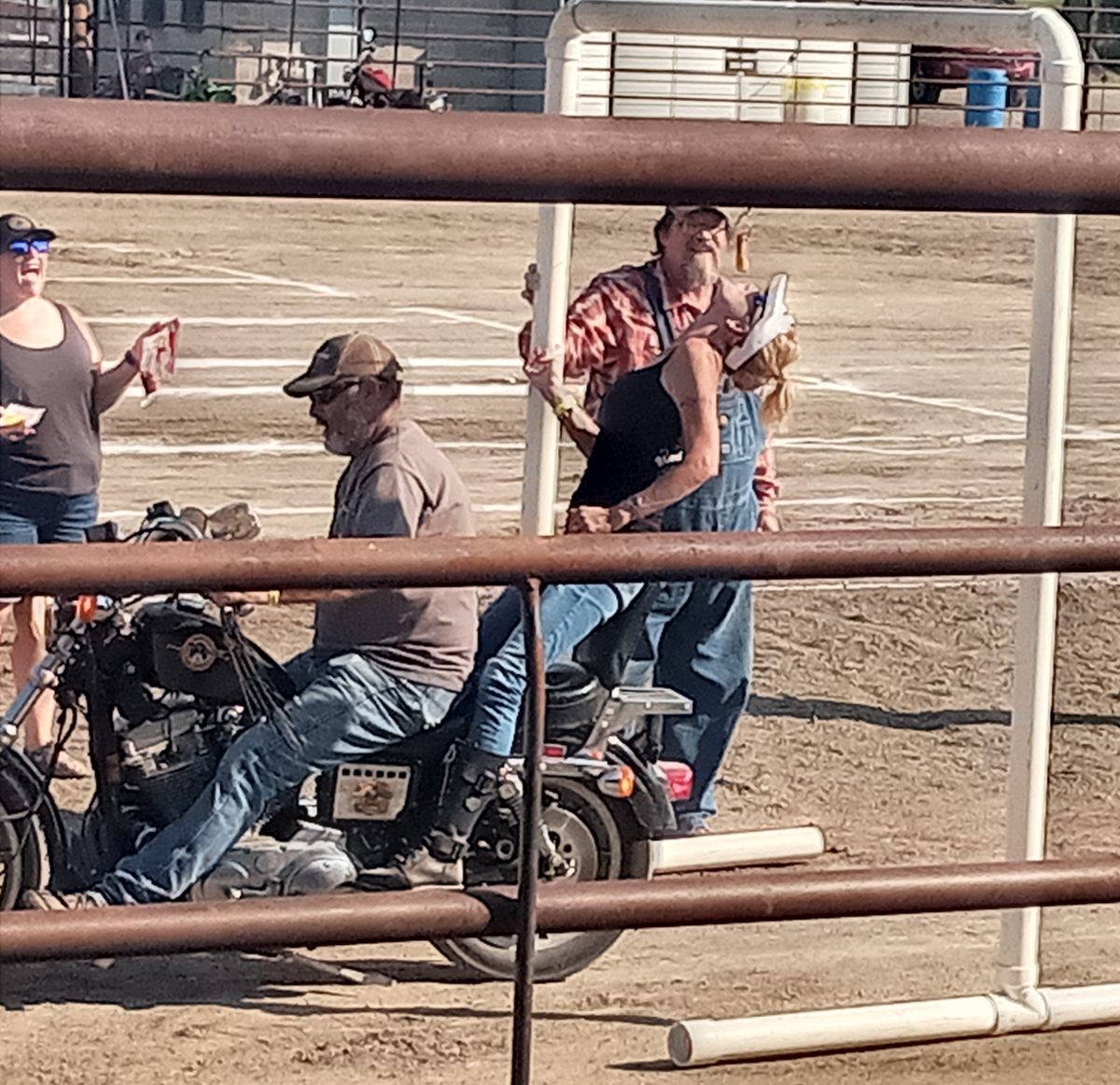 A woman participates in the weenie bite event from the back of a motorcycle