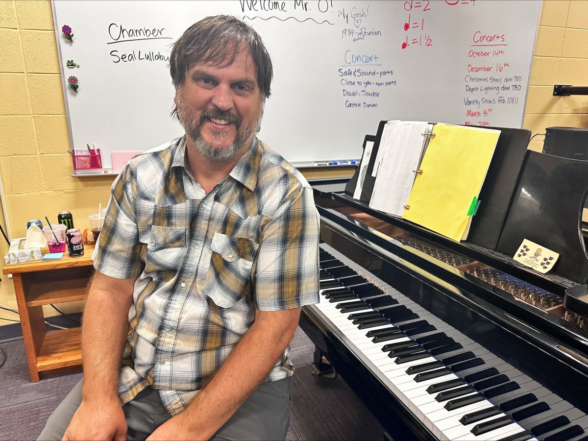 Clayton Oberquell sits by piano after teaching choir students.