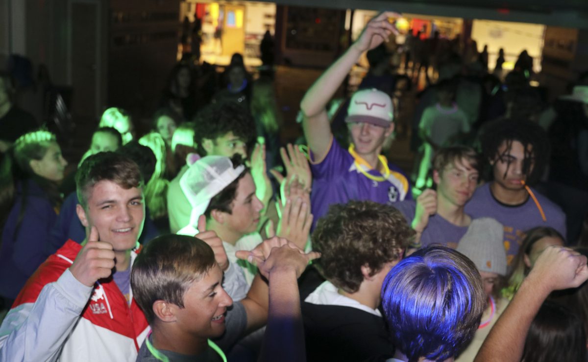 Junior and Senior boys come together under the neon lights at the 2021 Homecoming dance.