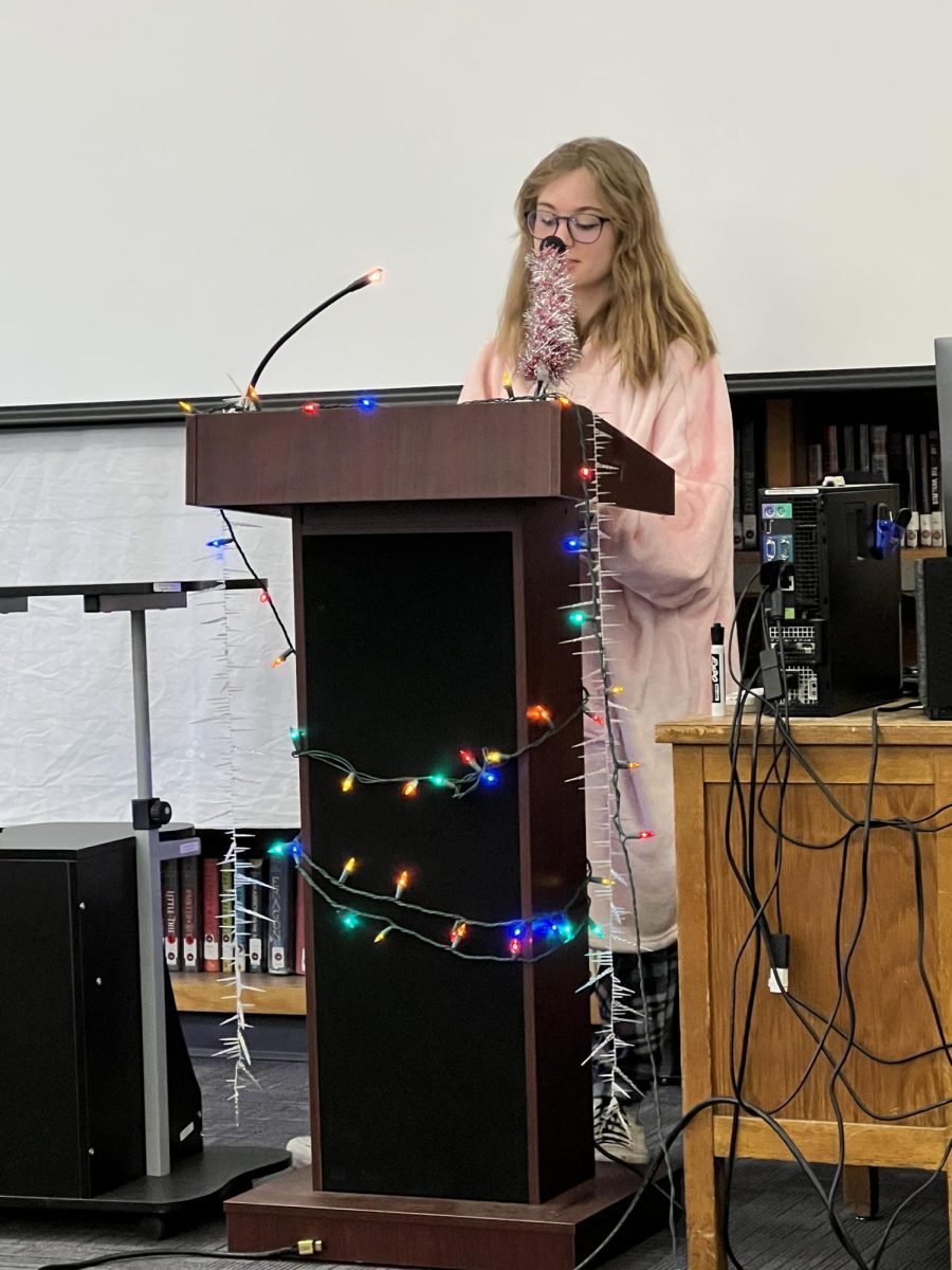 Ellie Ames reads her poem in the library.