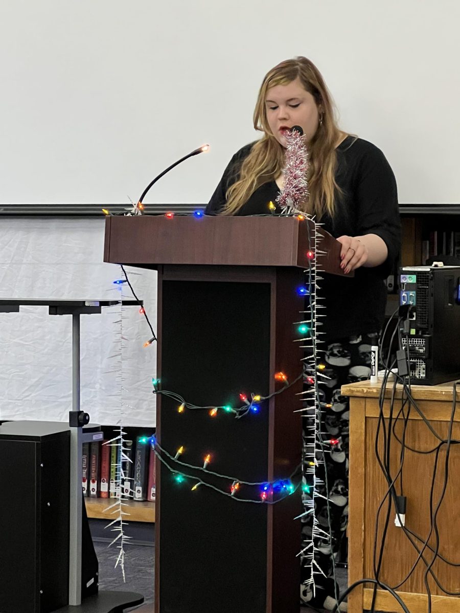 Trinity Borquez reads her original poem in the library.