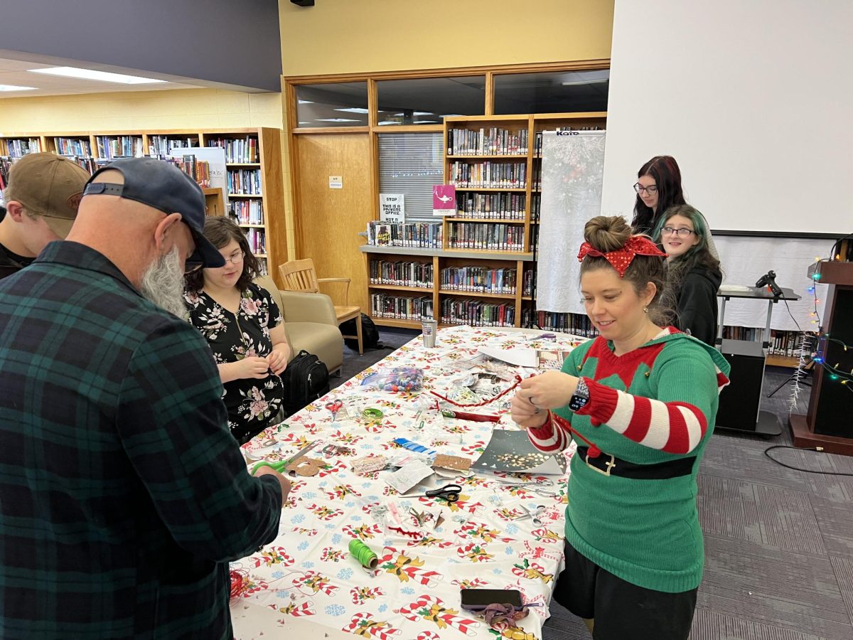 Kelly Dick and Sarah Mussetter make fused plastic bag snowflakes with students from their classes.