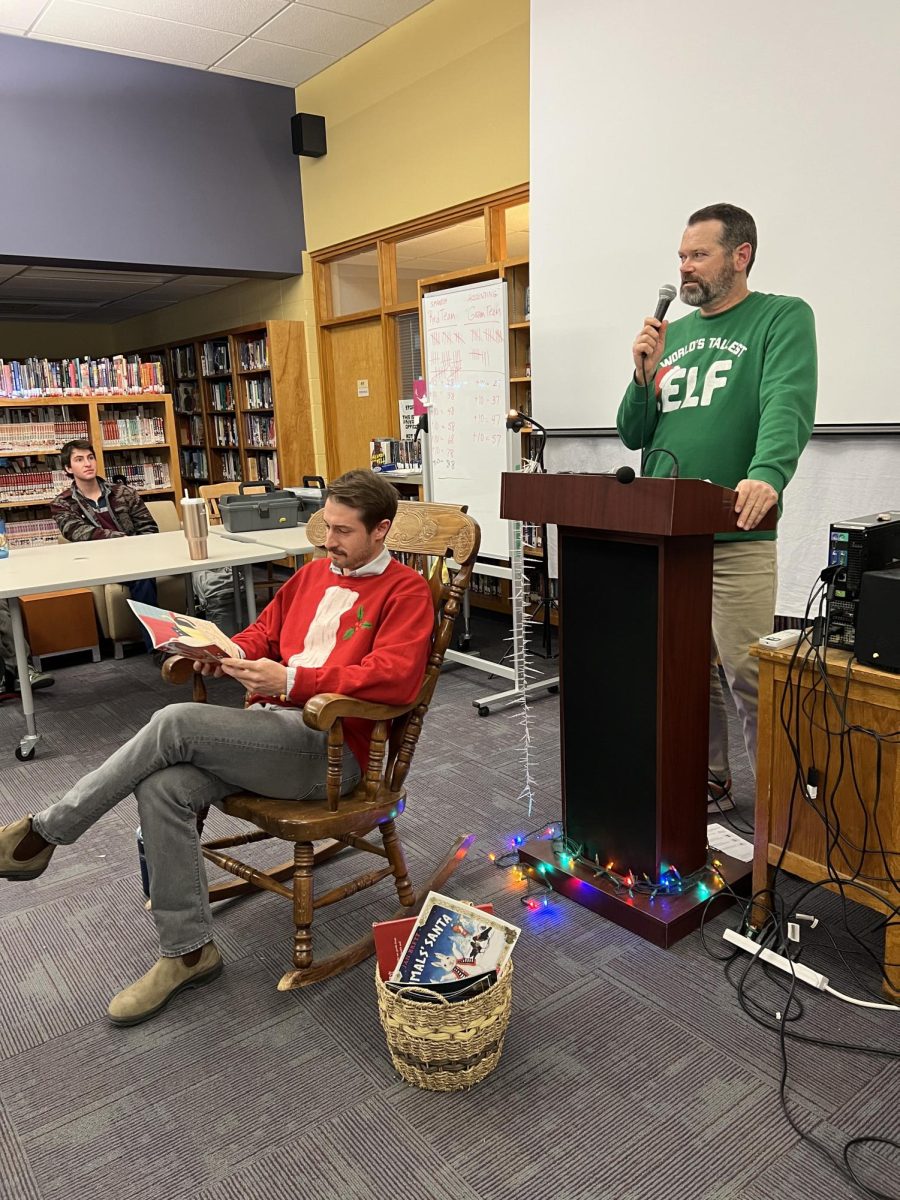 Reid Lende introduces the first guest reader, social studies teacher Andrew Marsh, who shared "The 12 Dogs of Christmas."