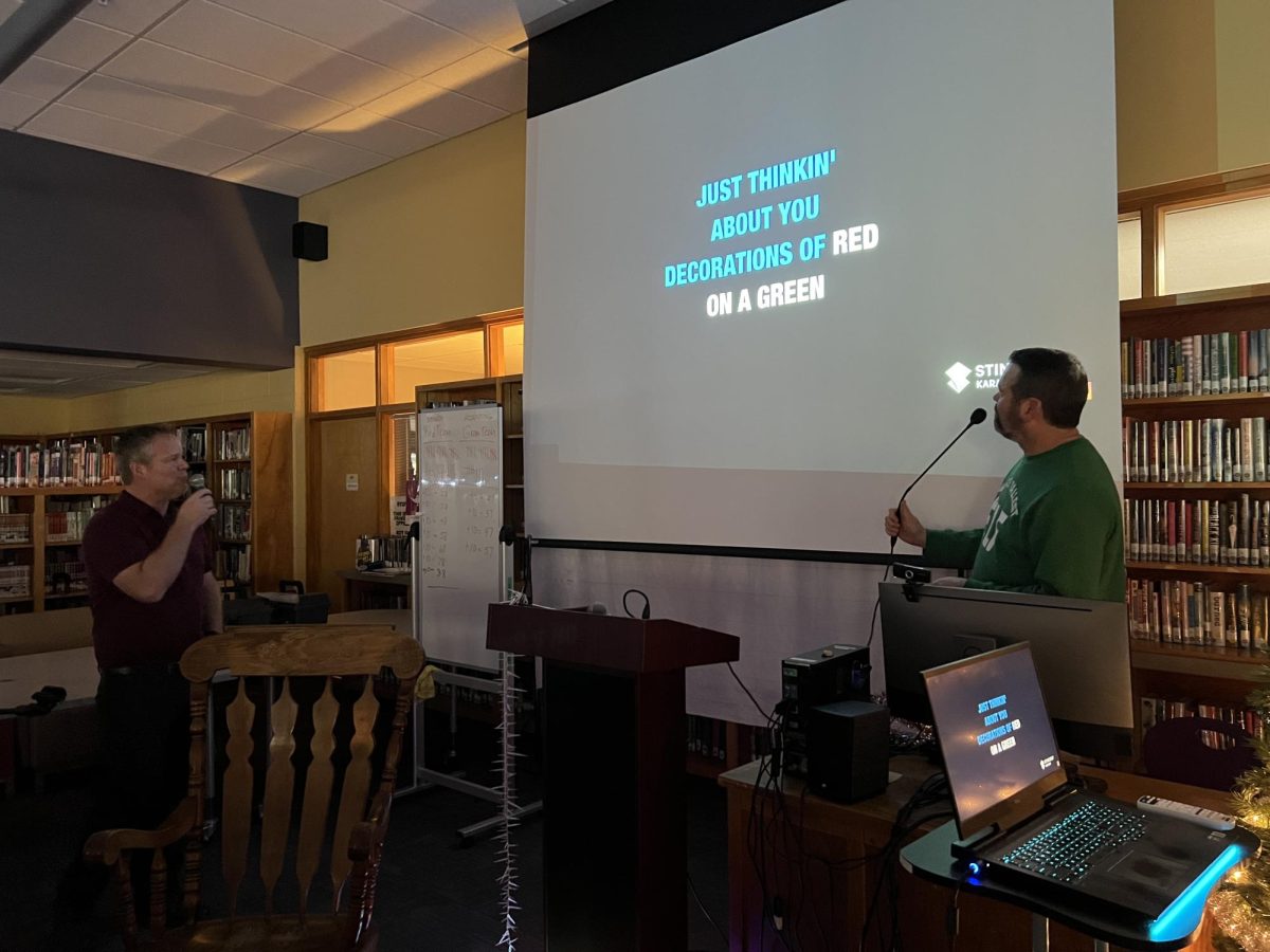 D-Pod teachers Bryan Beitel and Reid Lende sing "Blue Christmas" together to kick off the Christmas Karaoke session in the library.