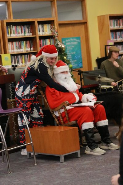 Holden Bankert as Clara Claus embraces Santa Claus, played by Lliam Edwards,  in the Christmas play.