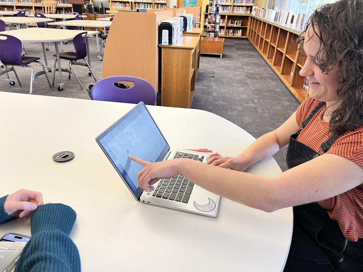 Junior Esme Grady points out a discussion assignment in her online Gothic Literature class to Jorja McCormick, who is also taking an online class sixth period.