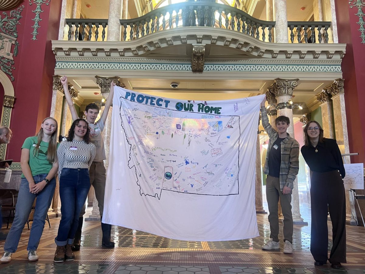 From left to right, Jorja McCormick, Esme Grady, Anders Harrison, Carson Bekedam, and Ripley Cunningham stand in front of their custom sign in the capital on Climate advocacy day.