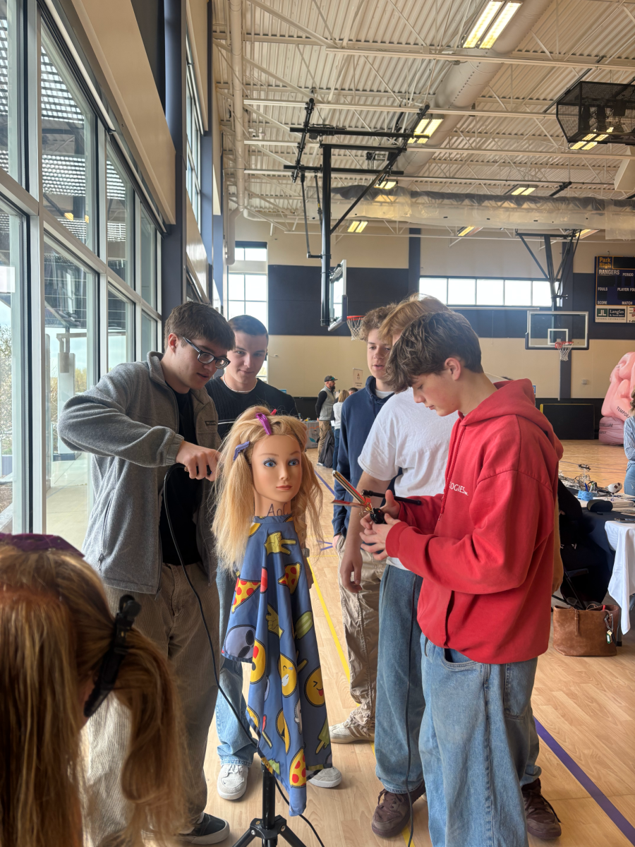 Greyson Mcallister, Caen Kipp, Noah Rudolph and Jackson Greisen practice their haircutting skills at the Park High career fair.