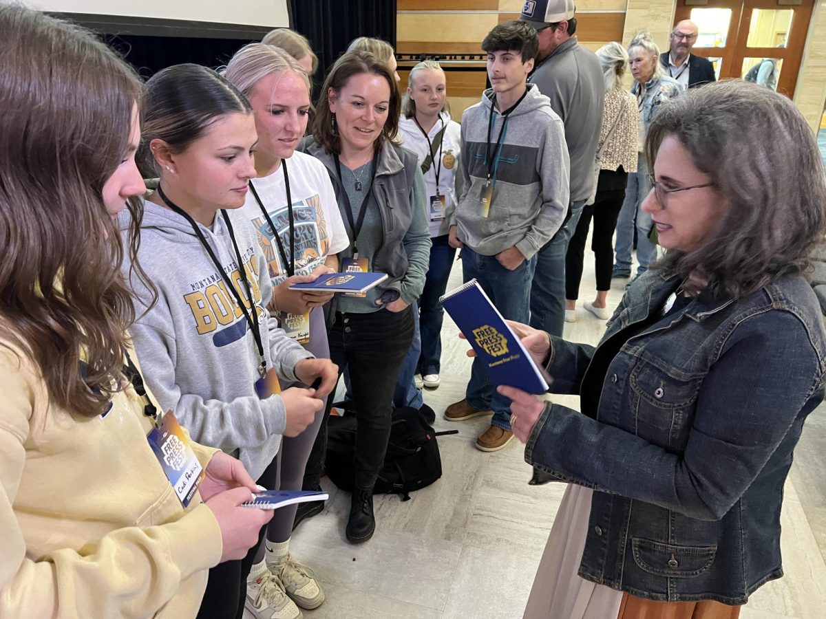 Amy Gamerman, author of The Crazies, signs reporters’ notebooks for Park High journalism students during the Montana Free Press Fest at Montana State University on Wednesday, Sept. 4. From left: Cadi Perkins, Isabella Fabich, Emma Knight, advisor Kate Lende, and FFA students.